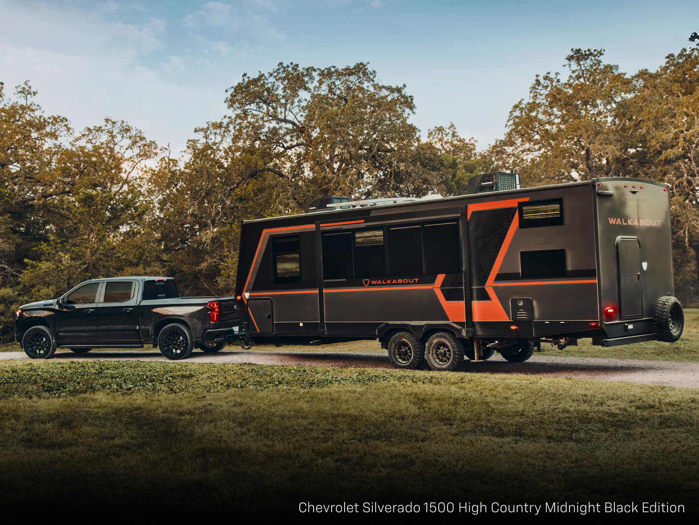A Chevrolet Silverado 1500 High Country Midnight Black Edition, towing a large Walkabout camper trailer